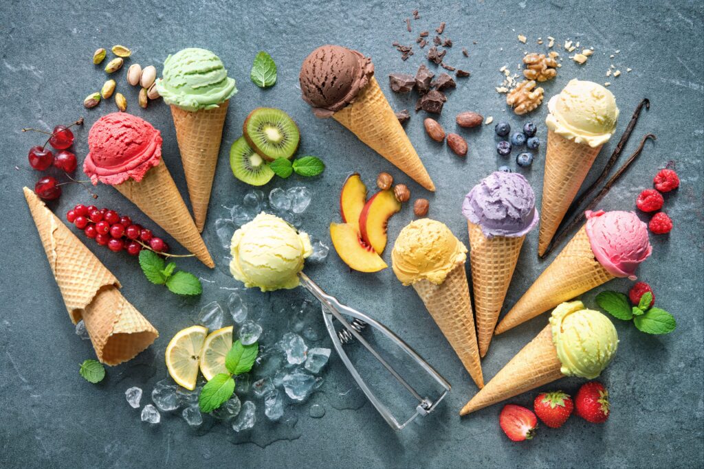 Assorted fruit-flavored ice cream cones with fresh fruit