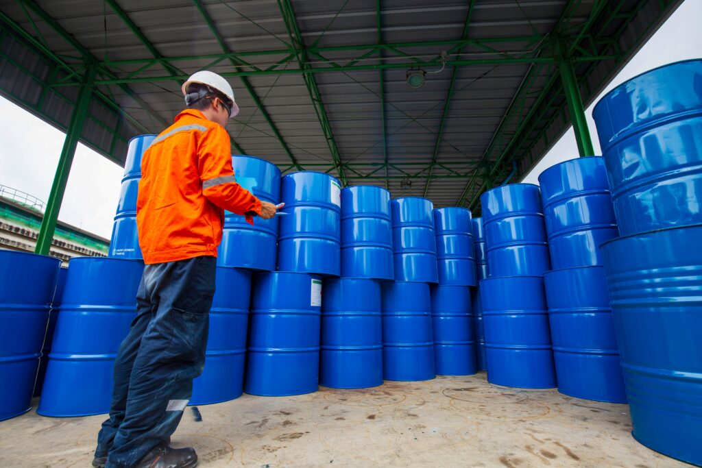 Worker inspecting commercial ingredient drums in a storage facility