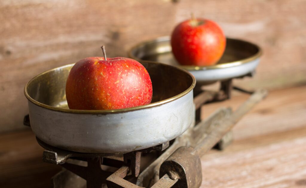 Two apples on a balance scale representing an equal fruit ingredient quote comparison